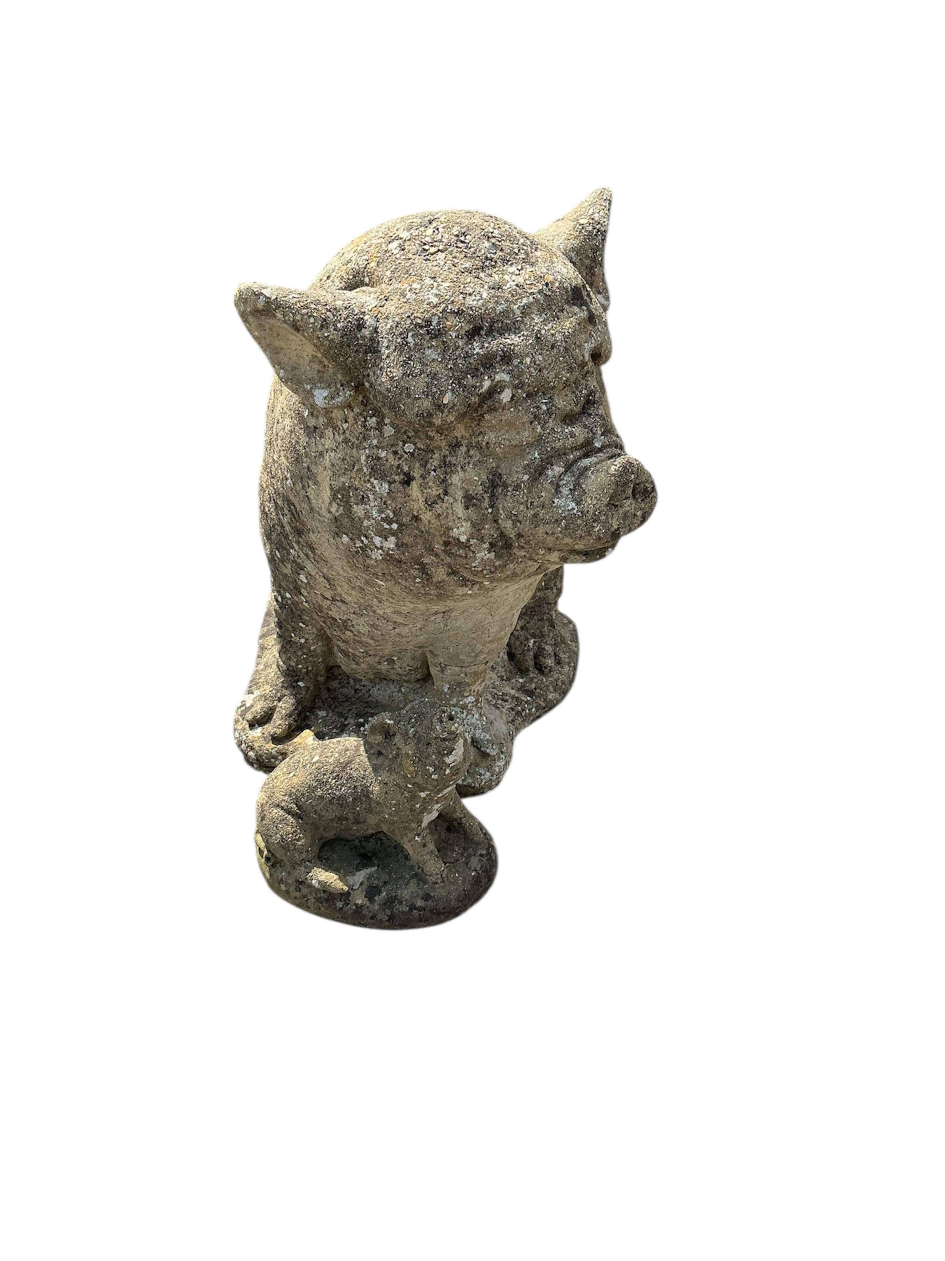 A reconstituted stone pig garden ornament and one smaller pig ornament, larger height 44cm